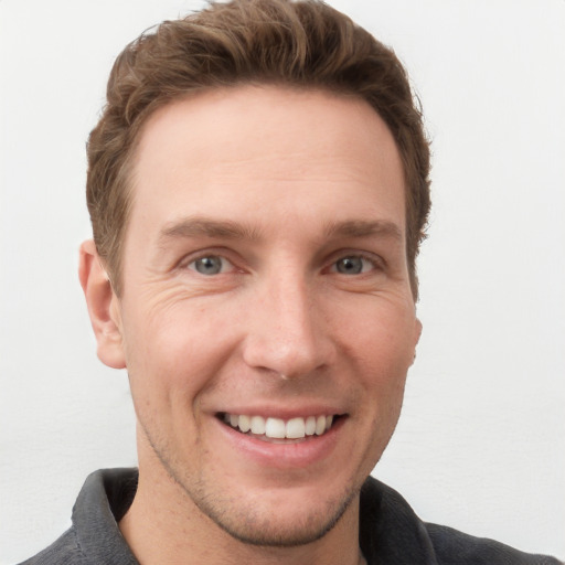 Joyful white young-adult male with short  brown hair and grey eyes