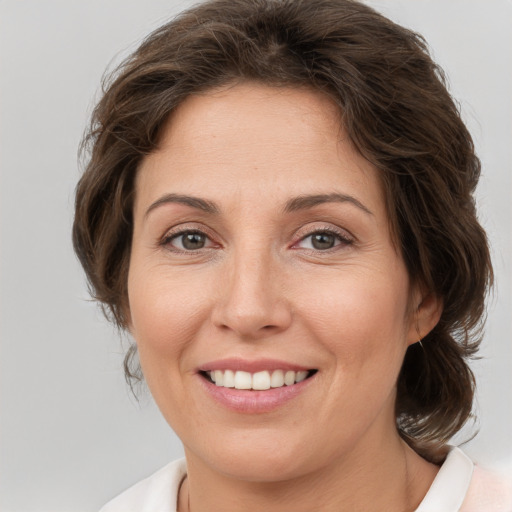 Joyful white adult female with medium  brown hair and brown eyes