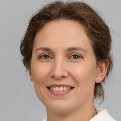 Joyful white adult female with medium  brown hair and green eyes