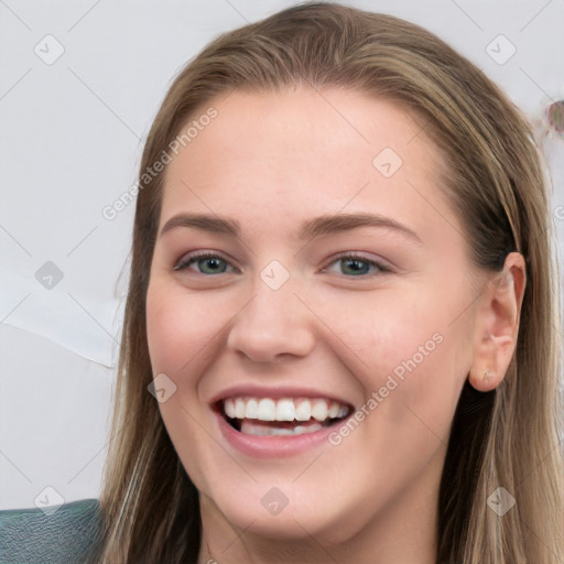 Joyful white young-adult female with long  brown hair and blue eyes