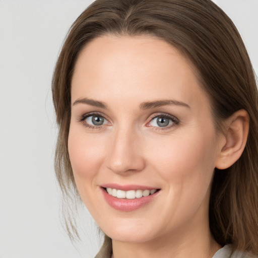 Joyful white young-adult female with long  brown hair and grey eyes