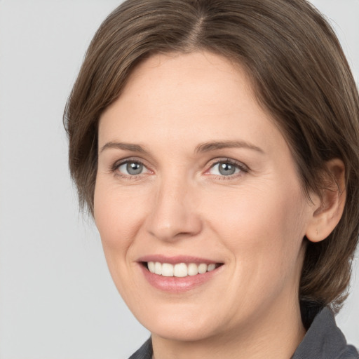 Joyful white adult female with medium  brown hair and grey eyes