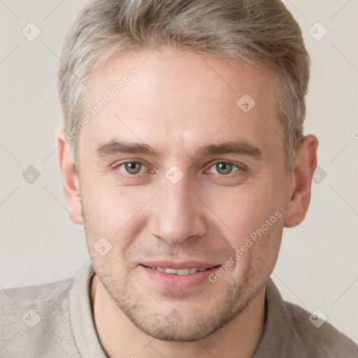 Joyful white adult male with short  brown hair and grey eyes