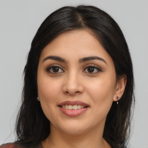 Joyful latino young-adult female with long  brown hair and brown eyes