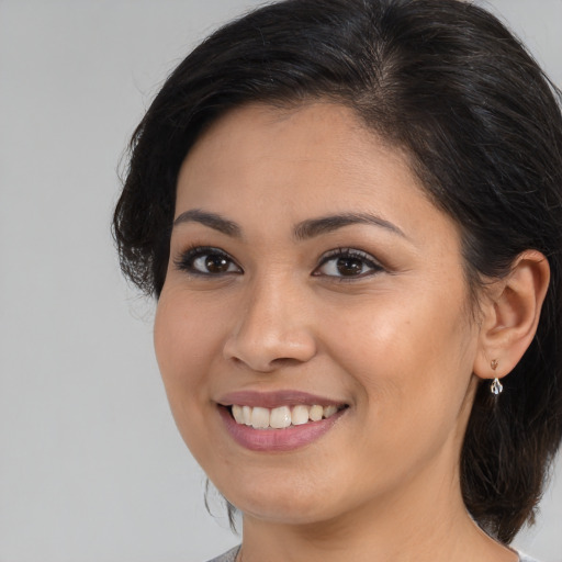 Joyful white young-adult female with medium  black hair and brown eyes