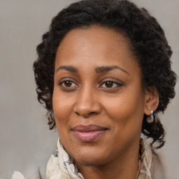 Joyful black adult female with medium  brown hair and brown eyes