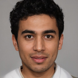 Joyful latino young-adult male with short  brown hair and brown eyes