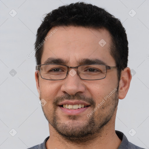 Joyful white young-adult male with short  black hair and brown eyes