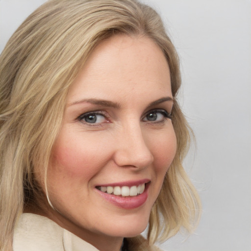 Joyful white young-adult female with medium  blond hair and blue eyes