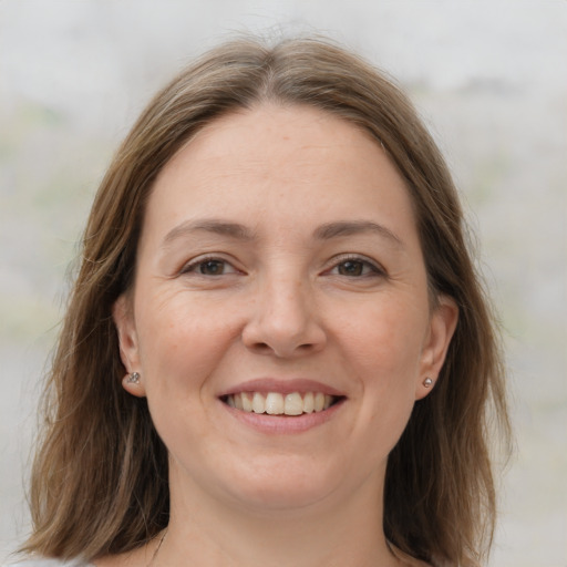 Joyful white young-adult female with medium  brown hair and grey eyes