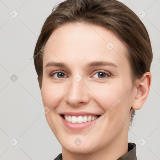 Joyful white young-adult female with short  brown hair and grey eyes