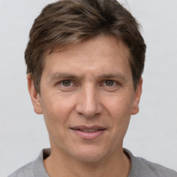 Joyful white adult male with short  brown hair and grey eyes