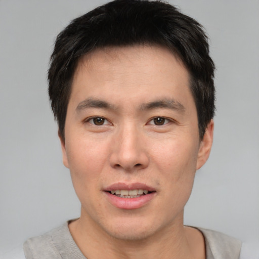 Joyful asian young-adult male with short  brown hair and brown eyes