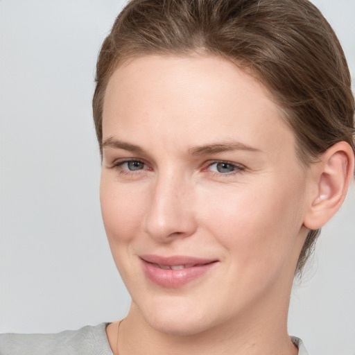 Joyful white young-adult female with medium  brown hair and grey eyes