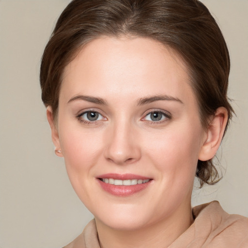 Joyful white young-adult female with medium  brown hair and grey eyes