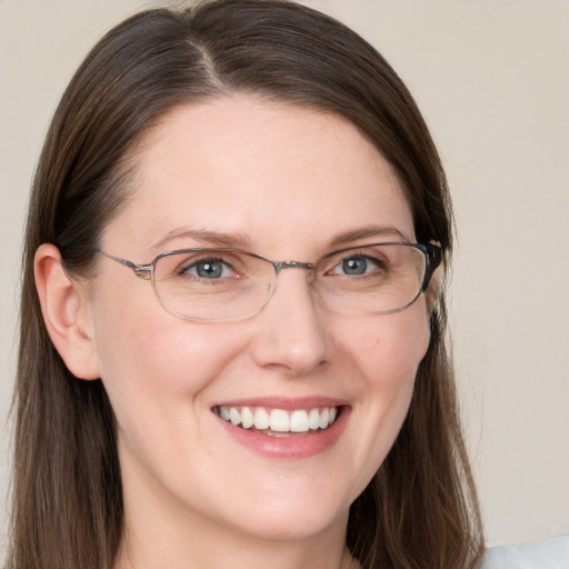 Joyful white adult female with long  brown hair and blue eyes