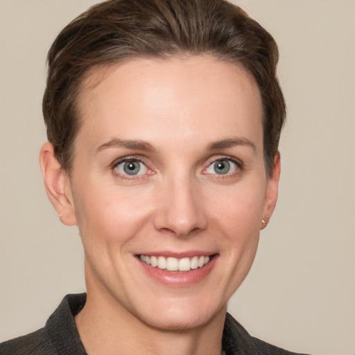 Joyful white young-adult female with short  brown hair and grey eyes