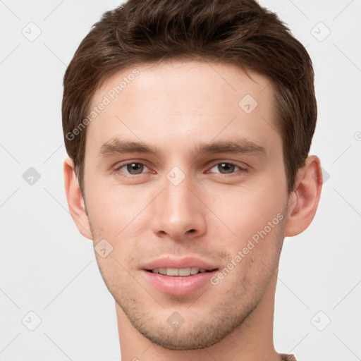 Joyful white young-adult male with short  brown hair and grey eyes