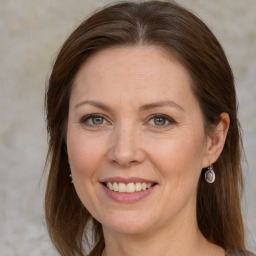 Joyful white adult female with long  brown hair and grey eyes