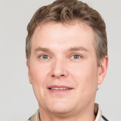 Joyful white adult male with short  brown hair and grey eyes