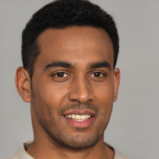 Joyful black young-adult male with short  brown hair and brown eyes