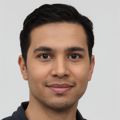 Joyful latino young-adult male with short  brown hair and brown eyes