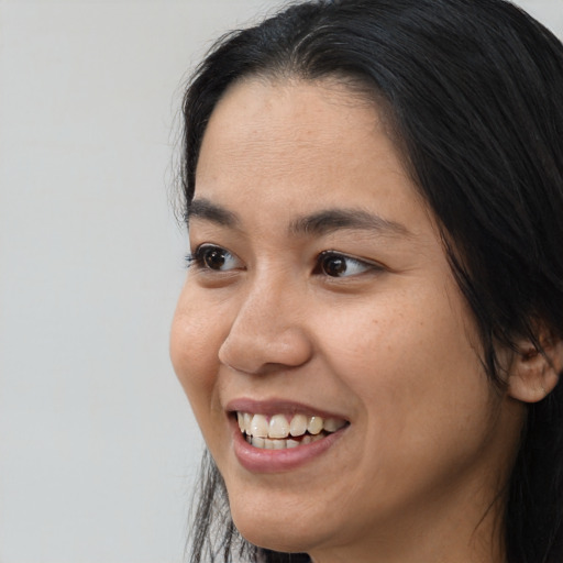 Joyful asian young-adult female with medium  brown hair and brown eyes