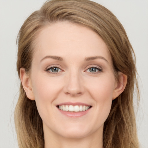 Joyful white young-adult female with long  brown hair and grey eyes