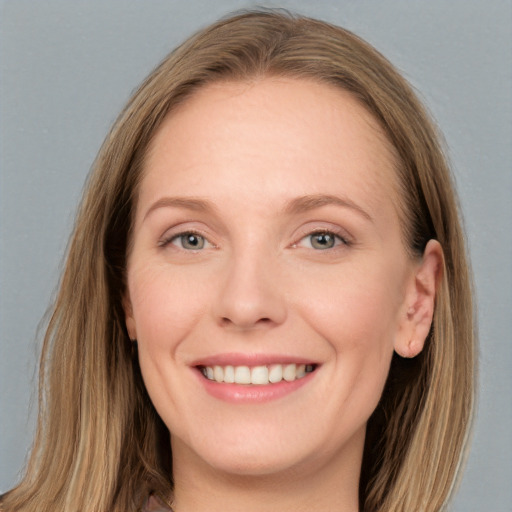 Joyful white young-adult female with long  brown hair and blue eyes