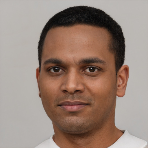 Joyful black young-adult male with short  black hair and brown eyes