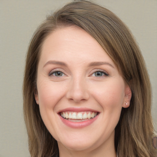 Joyful white young-adult female with long  brown hair and grey eyes