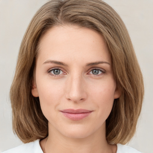 Joyful white young-adult female with medium  brown hair and green eyes