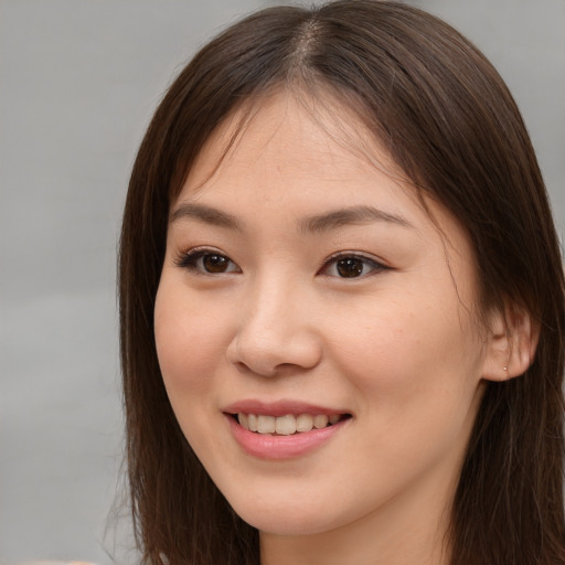 Joyful asian young-adult female with long  brown hair and brown eyes