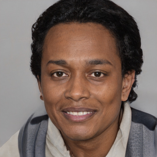 Joyful black adult female with short  black hair and brown eyes