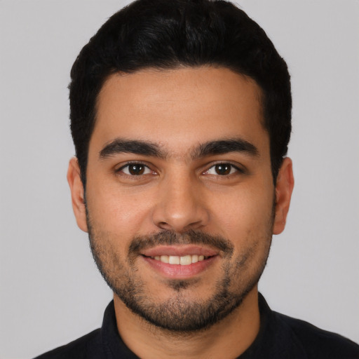 Joyful latino young-adult male with short  black hair and brown eyes