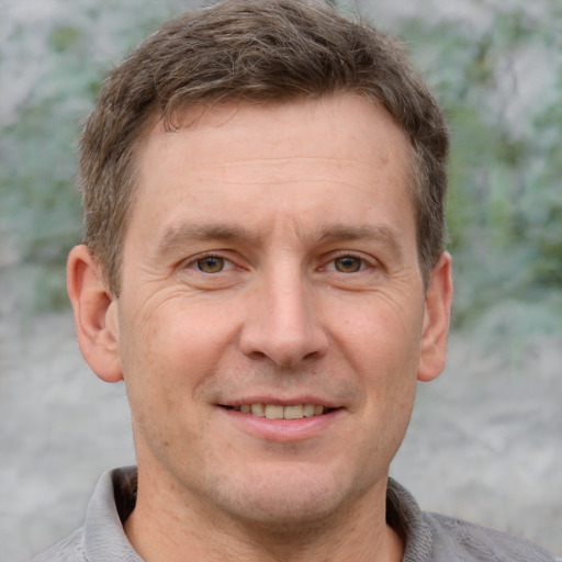 Joyful white adult male with short  brown hair and grey eyes