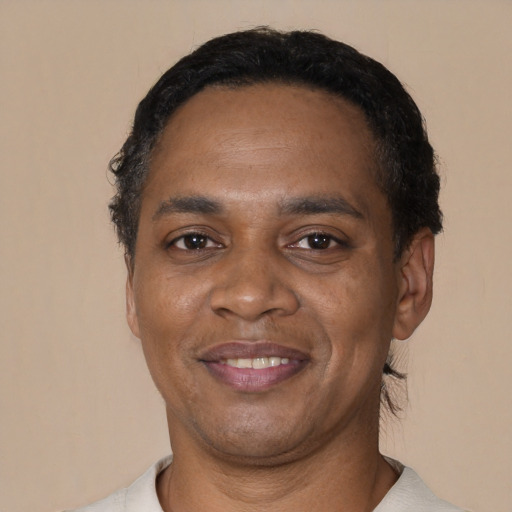 Joyful black young-adult male with short  black hair and brown eyes