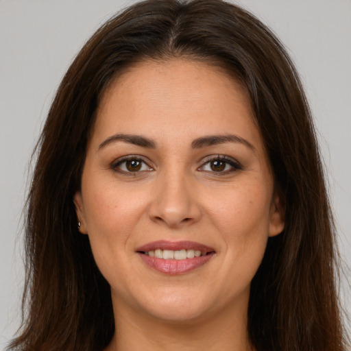 Joyful white young-adult female with long  brown hair and brown eyes