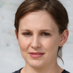 Joyful white young-adult female with medium  brown hair and grey eyes