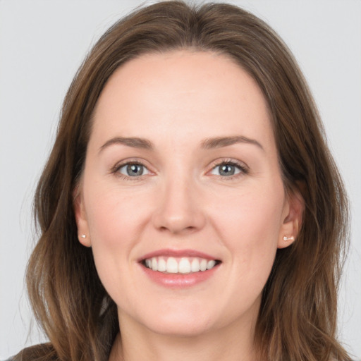 Joyful white young-adult female with long  brown hair and grey eyes