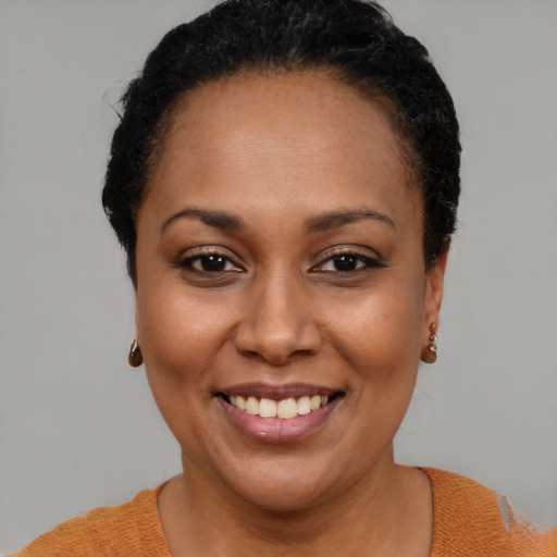 Joyful black young-adult female with short  brown hair and brown eyes