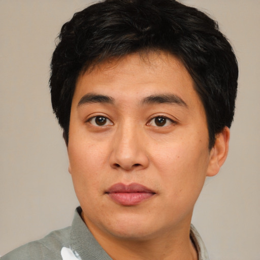 Joyful asian young-adult male with short  brown hair and brown eyes