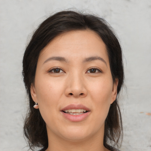 Joyful asian adult female with medium  brown hair and brown eyes