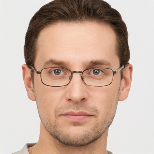 Joyful white young-adult male with short  brown hair and grey eyes