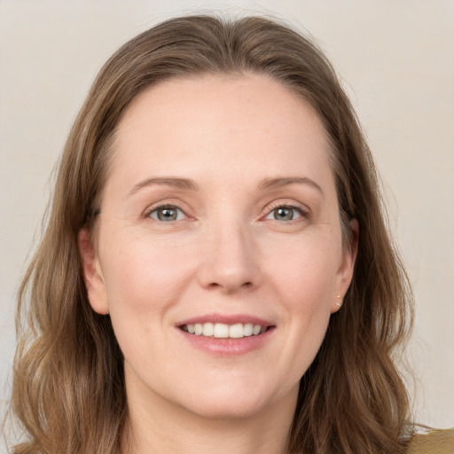 Joyful white young-adult female with long  brown hair and grey eyes