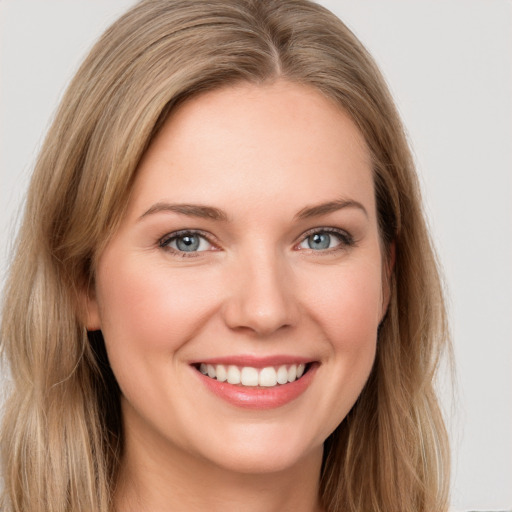 Joyful white young-adult female with long  brown hair and green eyes