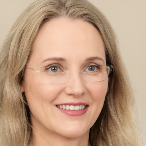 Joyful white adult female with long  brown hair and blue eyes