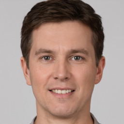 Joyful white young-adult male with short  brown hair and grey eyes