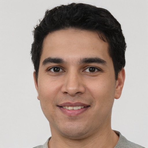 Joyful white young-adult male with short  black hair and brown eyes