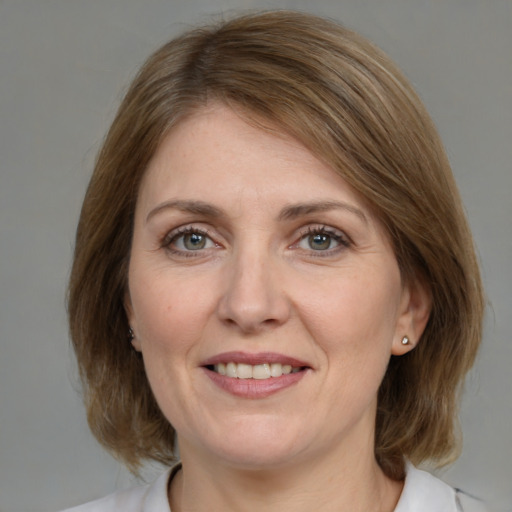 Joyful white adult female with medium  brown hair and grey eyes